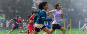 School children participating in a physical education activity, running on a playground to promote fitness, teamwork, and healthy lifestyle.